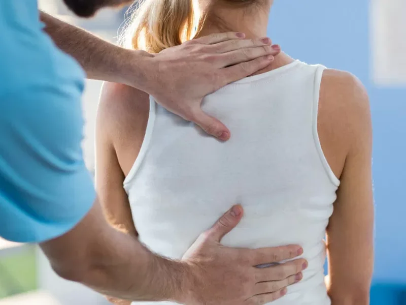 Close-up of a physical therapist working along a patient's back muscles by hand at HJ Manhattan Physical Therapy